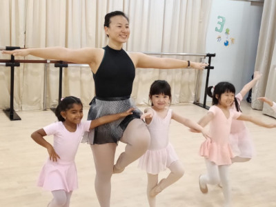 Fine momentum dance class students and instructor doing ballet poses