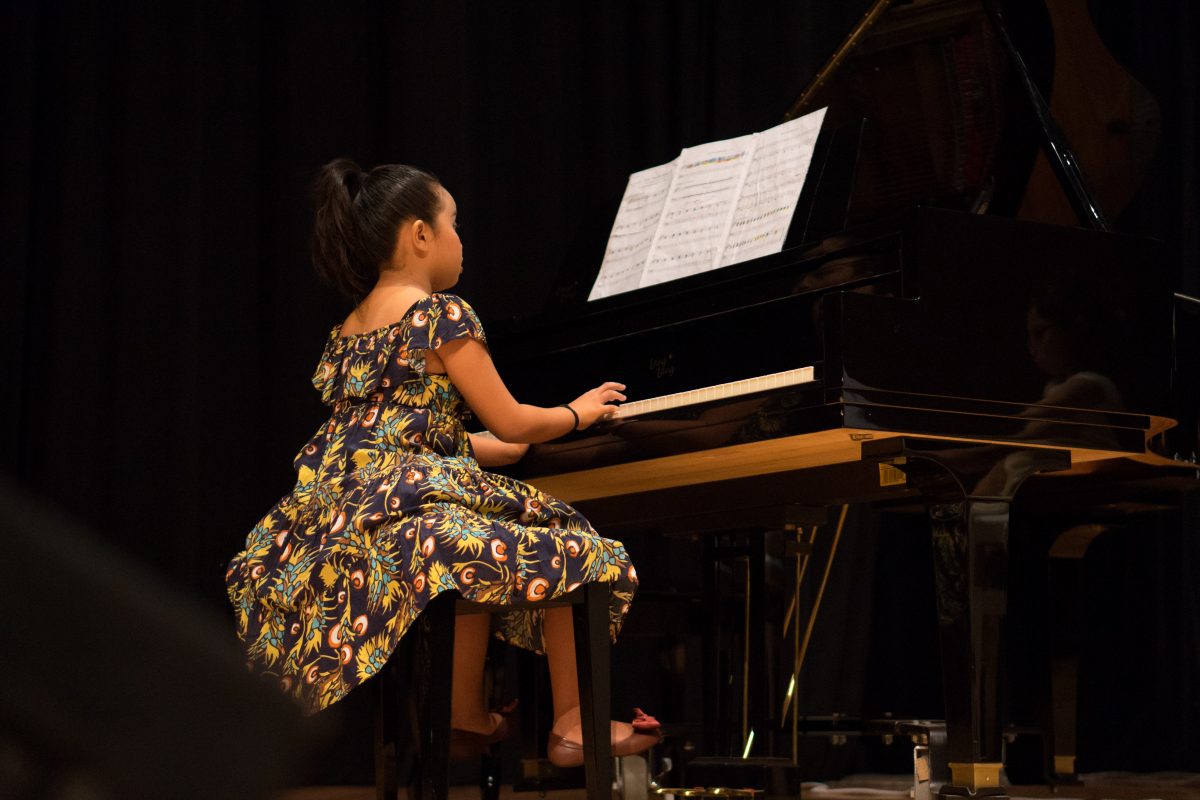 Fine Momentum music class student performing the piano on stage