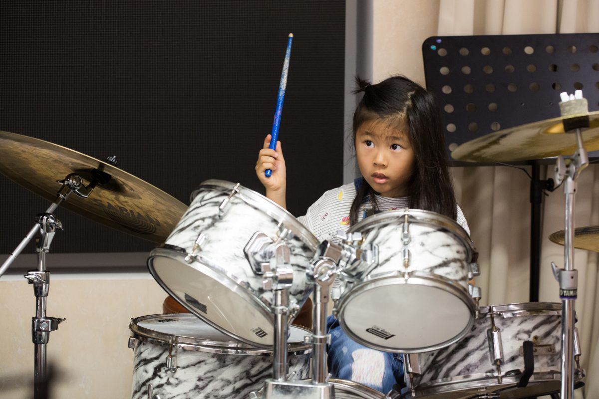 Fine momentum music lesson student performing the drums