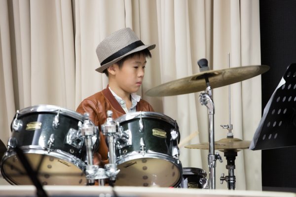 Fine momentum music lesson student performing the drums
