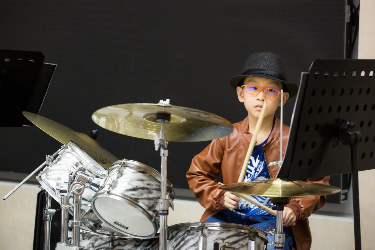 Fine momentum music lesson student performing the drums