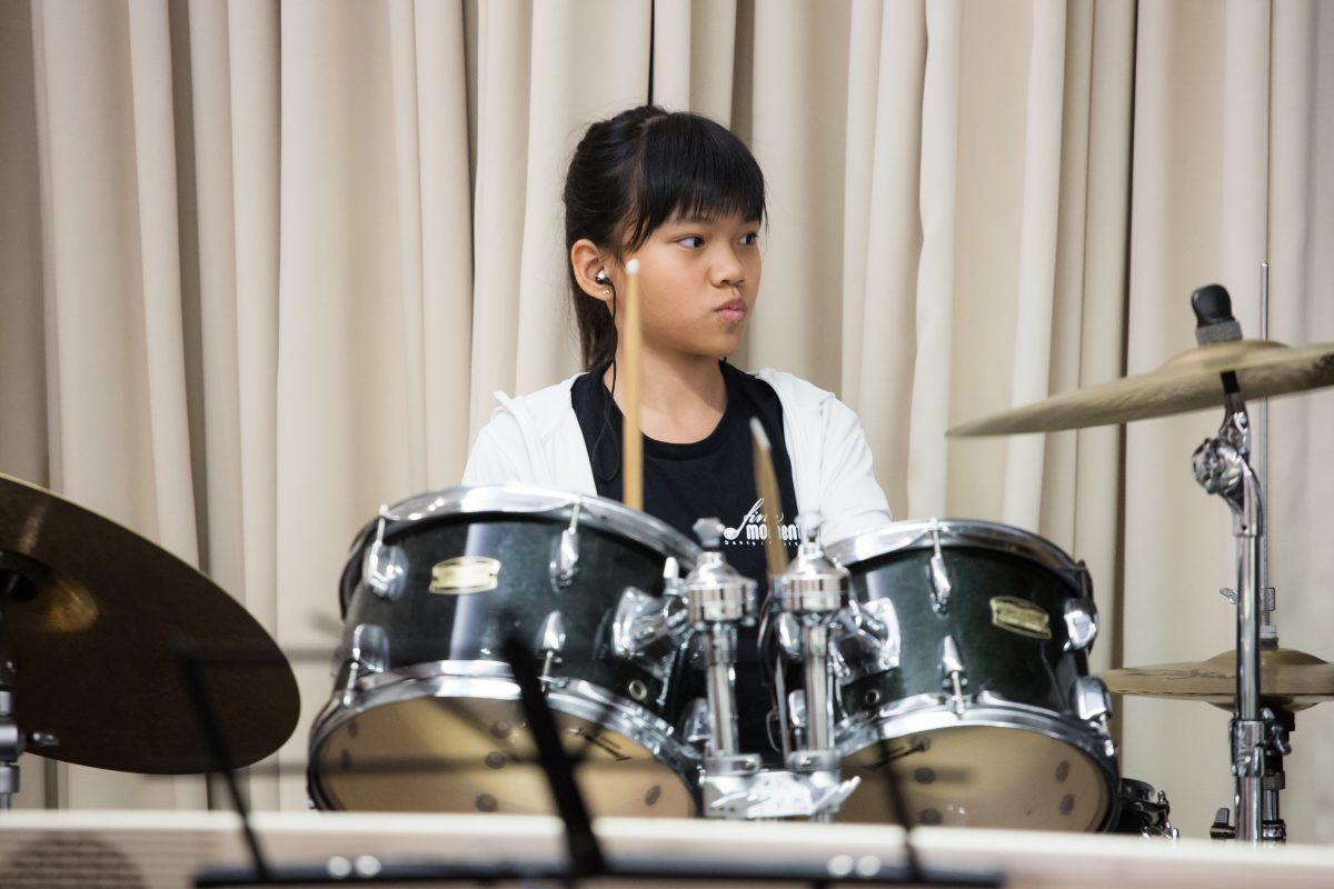 Fine momentum music lesson student performing the drums