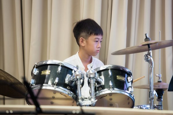 Fine momentum music lesson student performing the drums