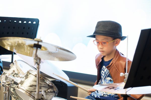 Fine momentum music lesson student performing the drums