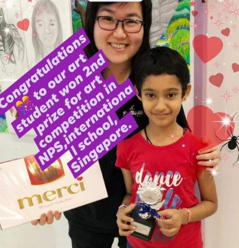 Our art student at Fine momentum showcasing their artwork with instructor at art competition