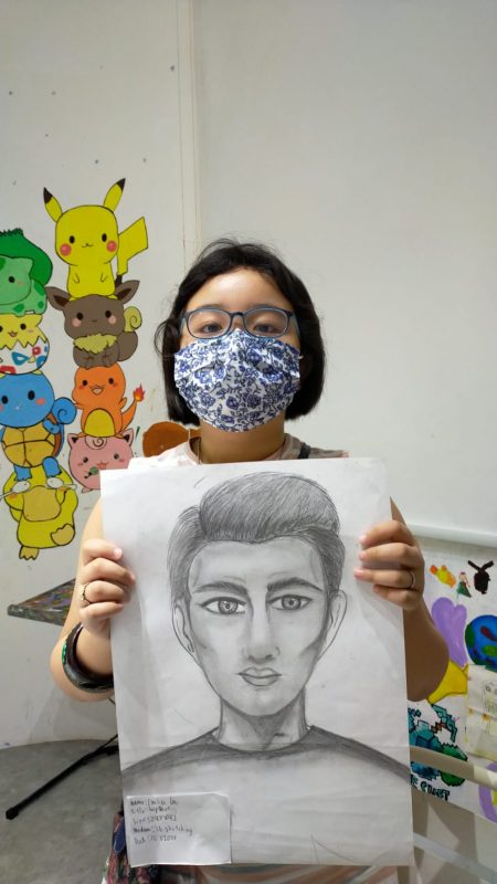 Fine momentum art class student showcasing her artwork