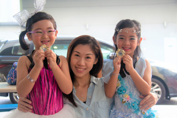 Fine momentum dance class students and instructor posing with dance competition medal