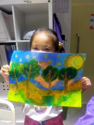 Fine momentum art class student showcasing her artwork