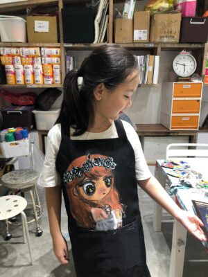 Our art students in their painted aprons after art lessons at Fine Momentum